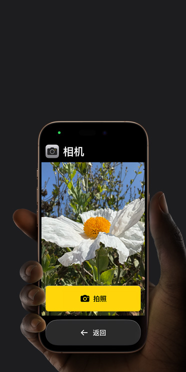 iPhone?16?Pro 屏幕显示精简的相机 app 界面，包括取景画面中的白色花朵、“拍照”按钮及其下方的“返回”按钮。
